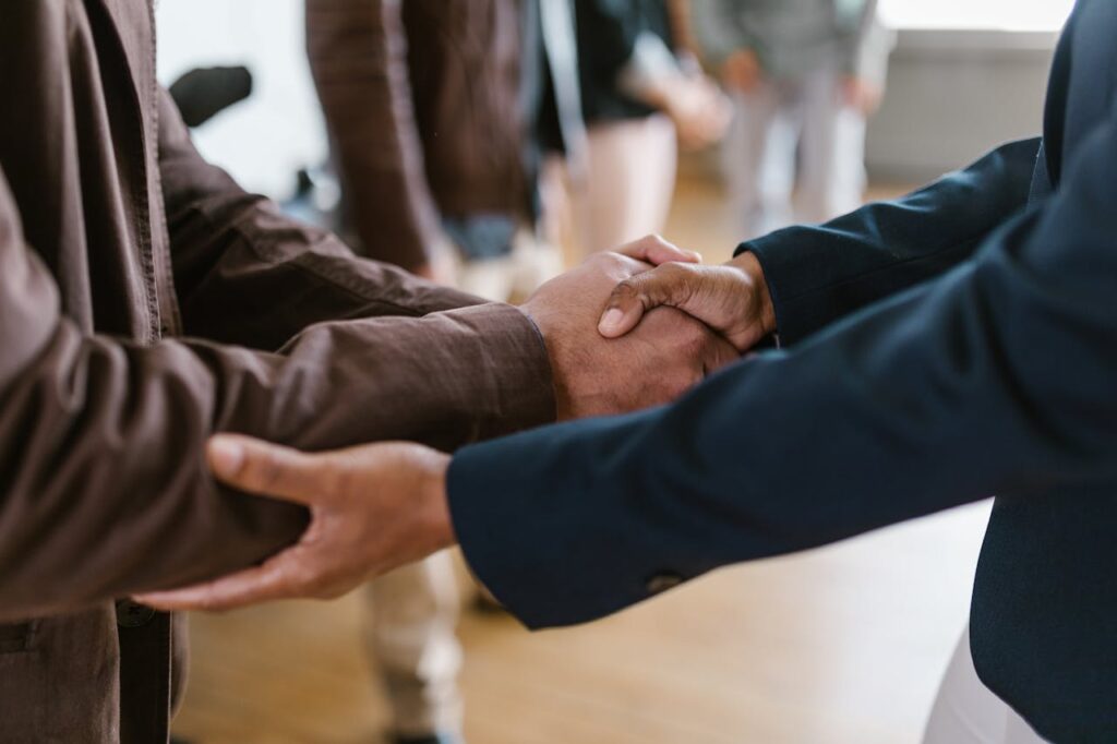 pexels-photo-7414284 Close-up of two businesspeople shaking hands, symbolizing agreement and partnership.